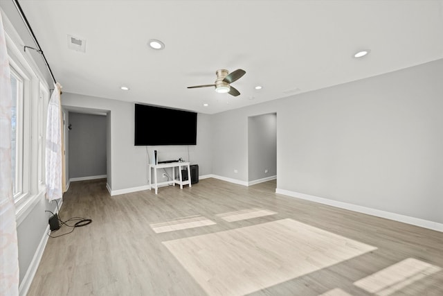 unfurnished living room featuring light wood-type flooring, a healthy amount of sunlight, and ceiling fan