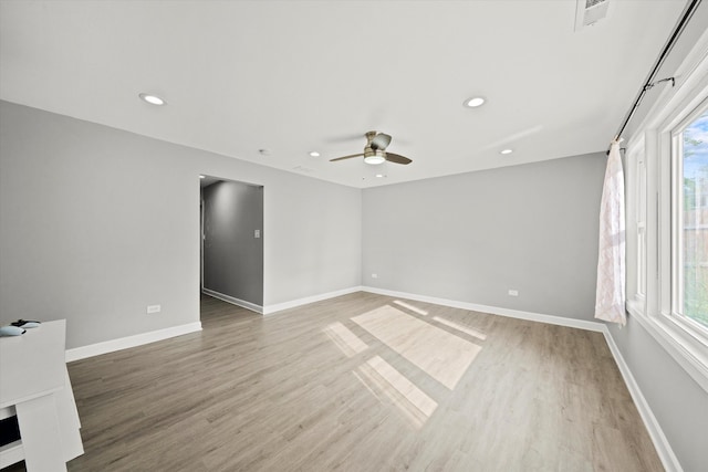 unfurnished room with ceiling fan, wood-type flooring, and a healthy amount of sunlight