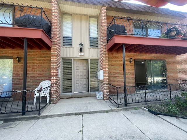 view of exterior entry featuring a balcony