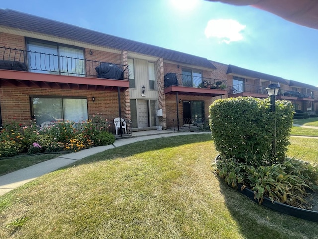 back of house featuring a yard and brick siding