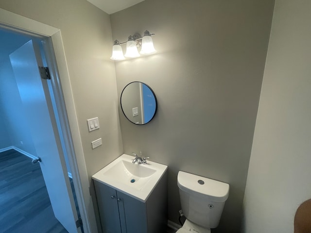 bathroom with vanity, toilet, and hardwood / wood-style flooring