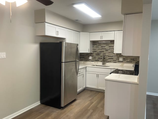 kitchen featuring dark hardwood / wood-style flooring, stainless steel appliances, sink, decorative backsplash, and ceiling fan