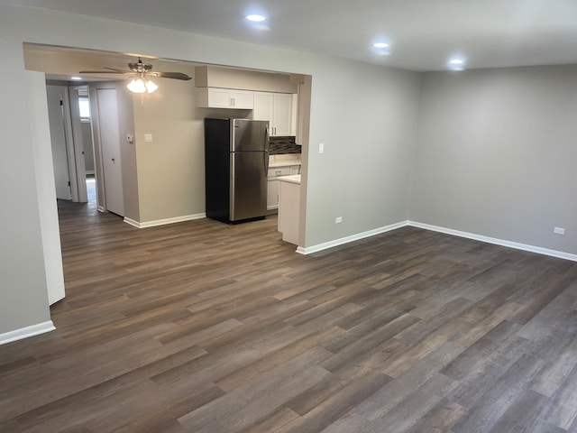 kitchen with dark hardwood / wood-style flooring, ceiling fan, stainless steel fridge, and white cabinetry