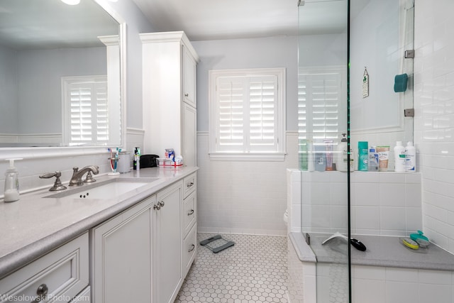 bathroom with vanity, tiled shower, and tile patterned floors