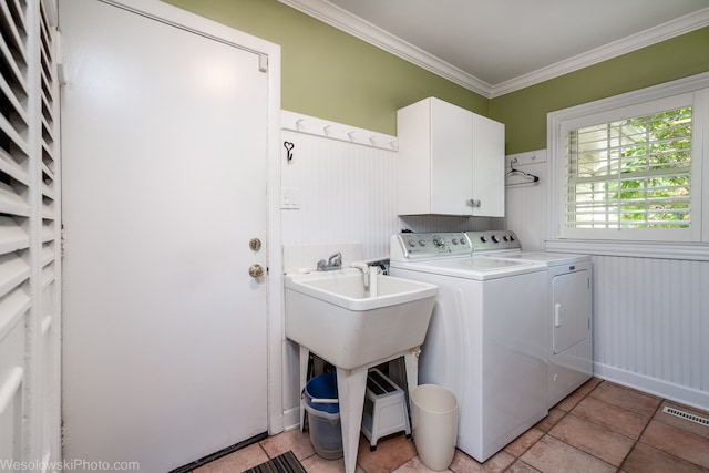 laundry room with crown molding, cabinets, and washing machine and dryer