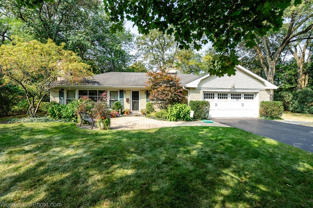 ranch-style house featuring a garage and a front lawn