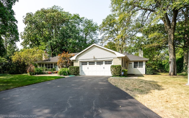 single story home featuring a garage and a front lawn