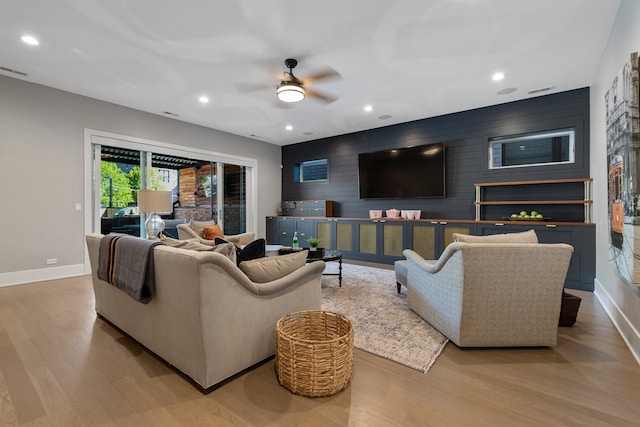 living room with light hardwood / wood-style flooring and ceiling fan