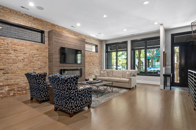 living room featuring brick wall and hardwood / wood-style floors