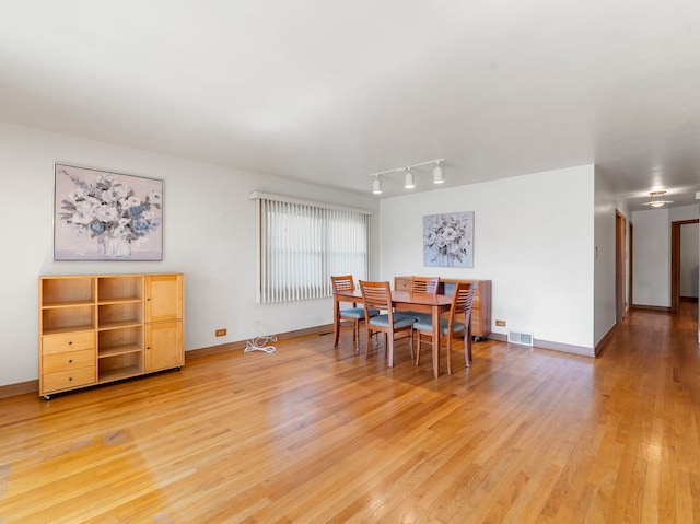 dining room featuring track lighting and light hardwood / wood-style floors