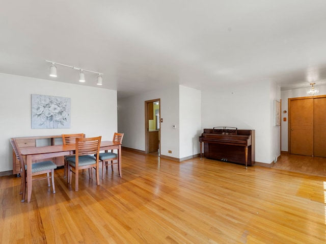 dining area featuring light wood-type flooring and track lighting