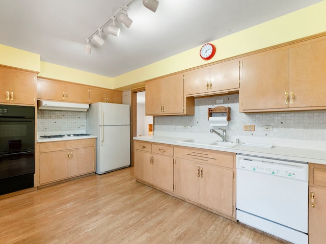 kitchen featuring light wood-type flooring, white appliances, tasteful backsplash, and sink