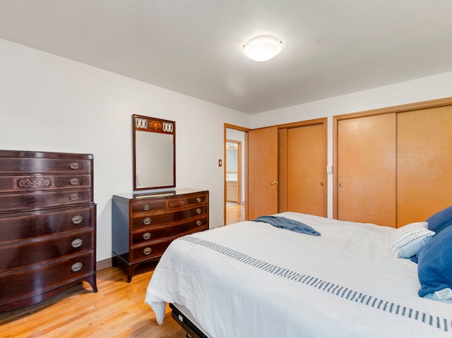 bedroom featuring light wood-type flooring and multiple closets