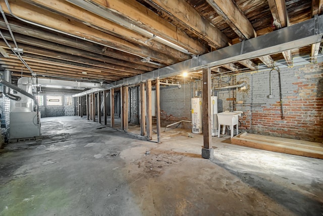 basement featuring brick wall, water heater, heating unit, and sink