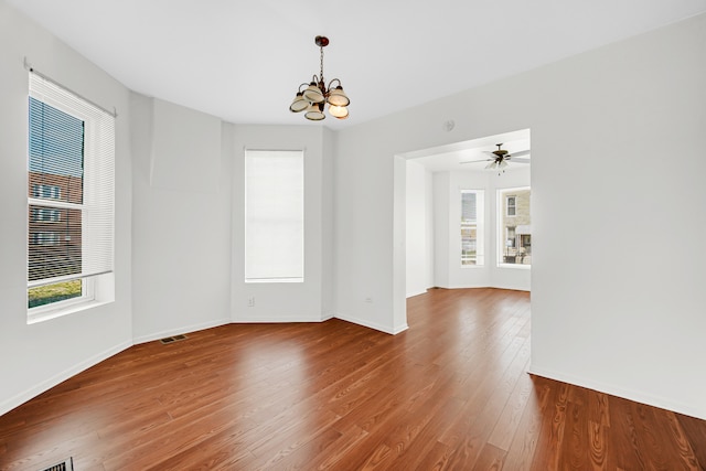 spare room featuring ceiling fan with notable chandelier and hardwood / wood-style flooring