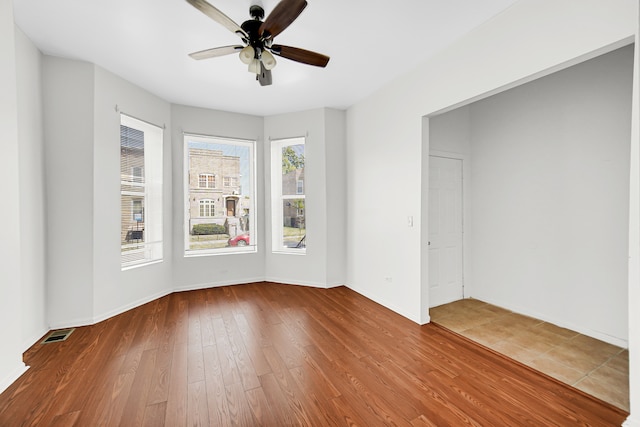 empty room with ceiling fan and wood-type flooring