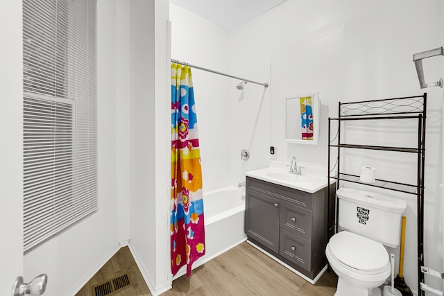 full bathroom featuring shower / bath combo with shower curtain, wood-type flooring, vanity, and toilet