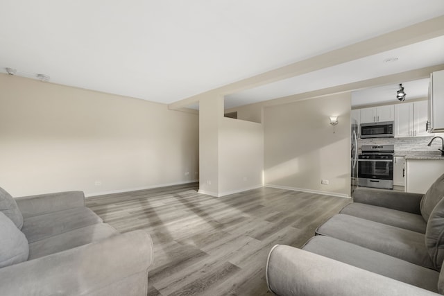 living room featuring light wood-type flooring and sink