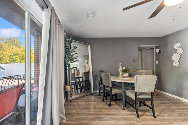 dining area featuring wood-type flooring and ceiling fan