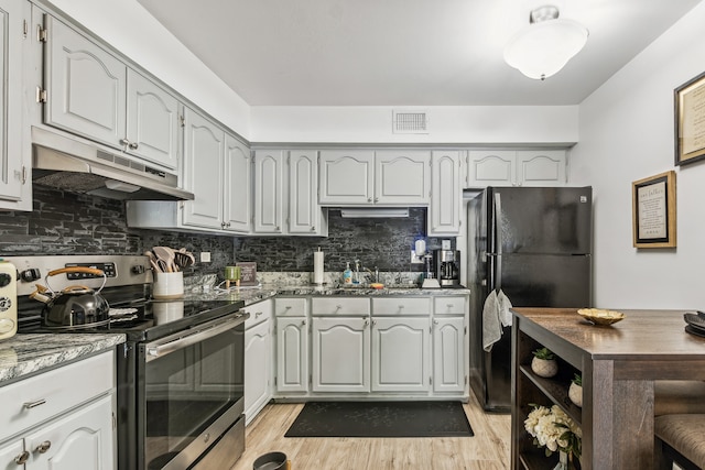 kitchen featuring tasteful backsplash, black refrigerator, gray cabinets, electric range, and light hardwood / wood-style floors