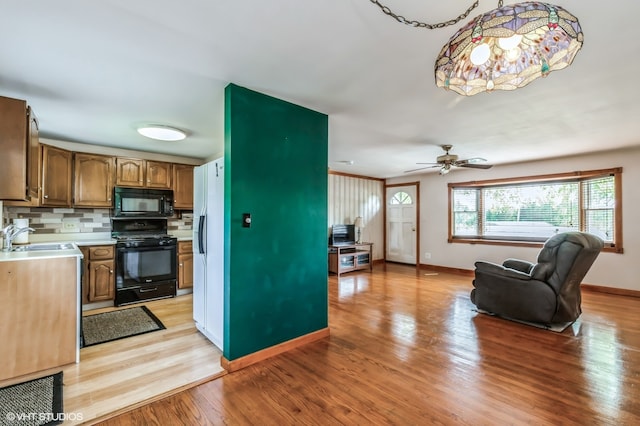 kitchen featuring black appliances, light hardwood / wood-style floors, sink, decorative backsplash, and ceiling fan