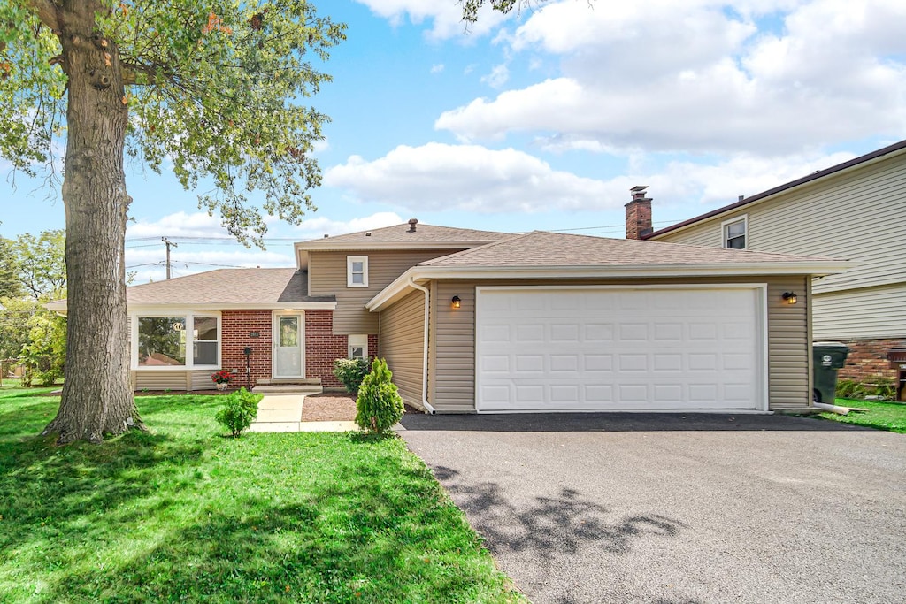 view of front of property with a garage and a front lawn