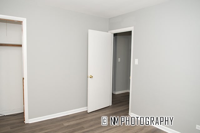 unfurnished bedroom featuring a closet and dark hardwood / wood-style flooring