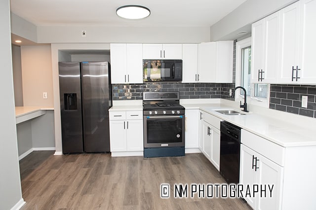 kitchen featuring white cabinets, sink, dark wood-type flooring, black appliances, and decorative backsplash