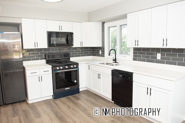 kitchen featuring black appliances, sink, and white cabinets