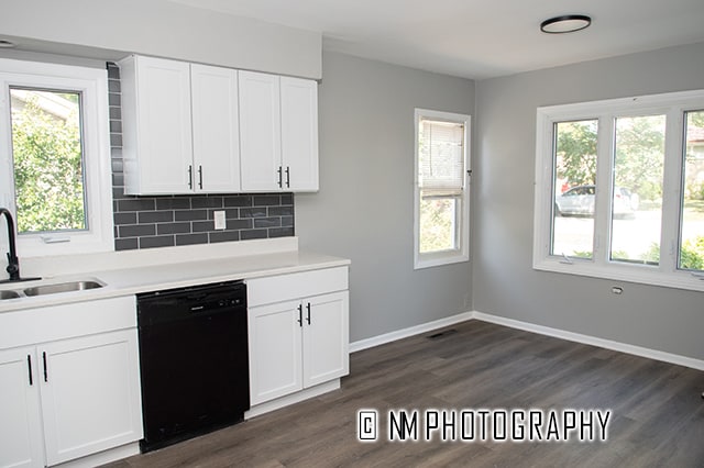 kitchen featuring dark hardwood / wood-style floors, backsplash, dishwasher, and sink