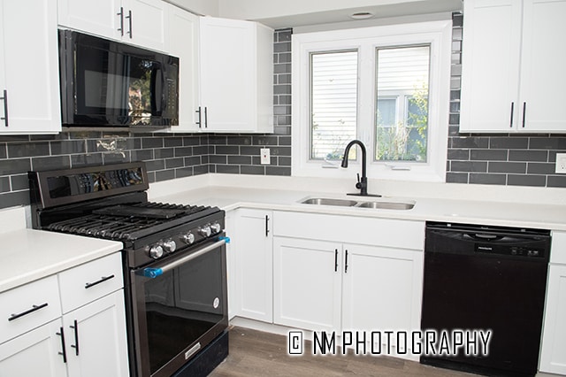 kitchen featuring decorative backsplash, white cabinetry, black appliances, dark hardwood / wood-style floors, and sink