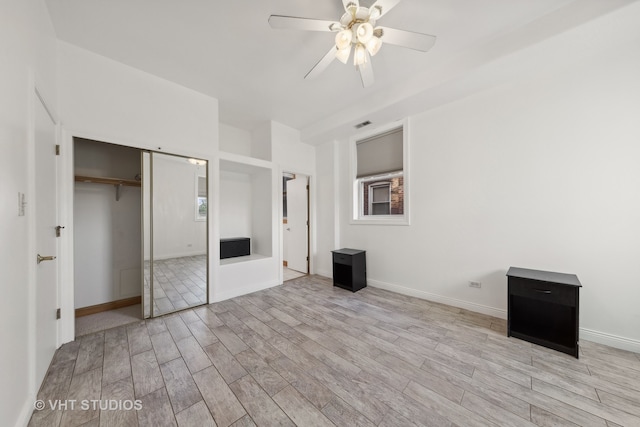 unfurnished bedroom featuring ceiling fan, a closet, and light hardwood / wood-style flooring