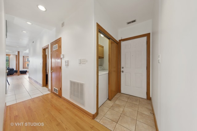 corridor with washer / clothes dryer and light hardwood / wood-style floors