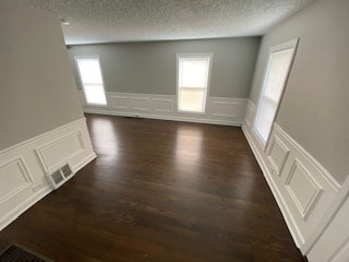 bonus room featuring a wealth of natural light, dark hardwood / wood-style flooring, and a textured ceiling