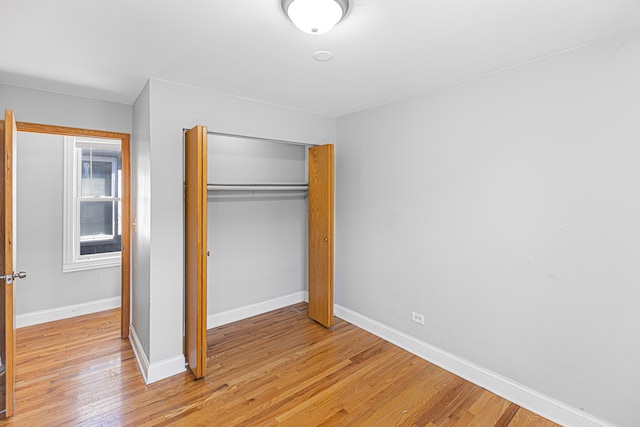 unfurnished bedroom with light hardwood / wood-style floors and a closet