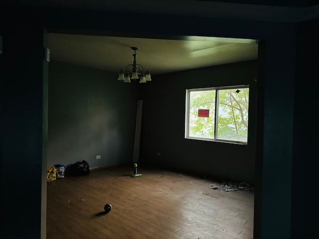 unfurnished room featuring hardwood / wood-style floors and a notable chandelier