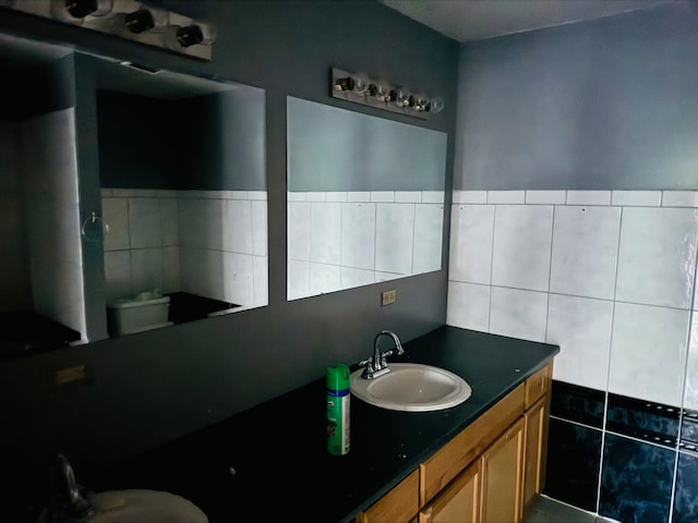 bathroom with vanity and tile walls