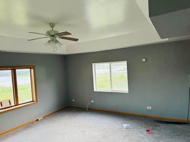 empty room featuring a wealth of natural light, ceiling fan, and carpet