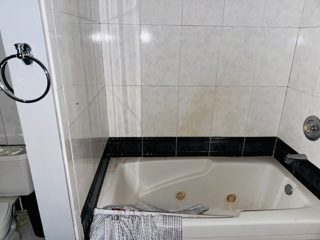 bathroom featuring toilet and a washtub