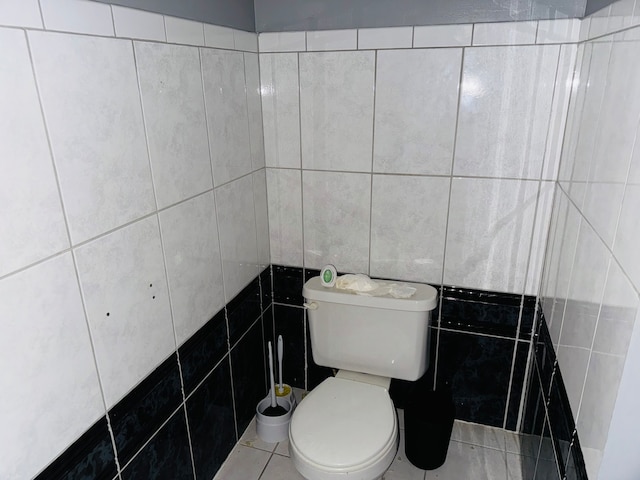 bathroom with tile walls, tile patterned flooring, and toilet