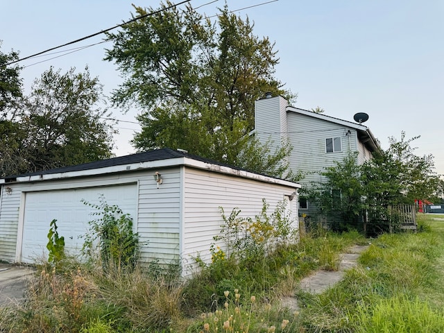 view of side of property featuring an outdoor structure and a garage