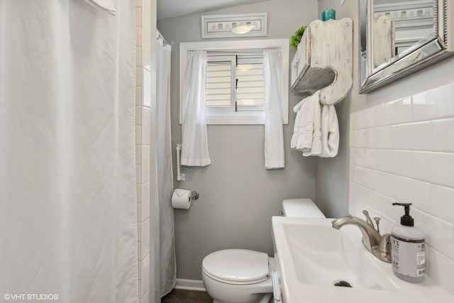 bathroom with vaulted ceiling, vanity, a shower with curtain, and toilet