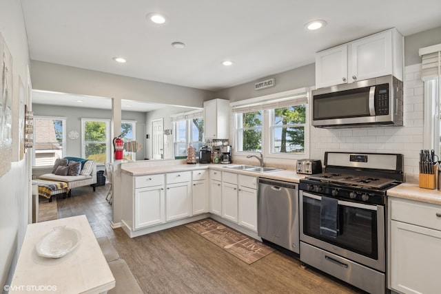 kitchen featuring appliances with stainless steel finishes, white cabinetry, and plenty of natural light