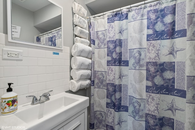 bathroom featuring walk in shower, decorative backsplash, vanity, and tile walls