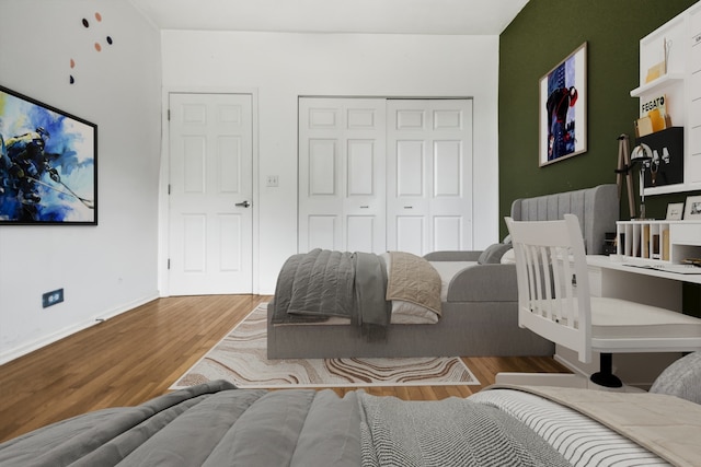 bedroom featuring light wood-type flooring, a closet, and radiator