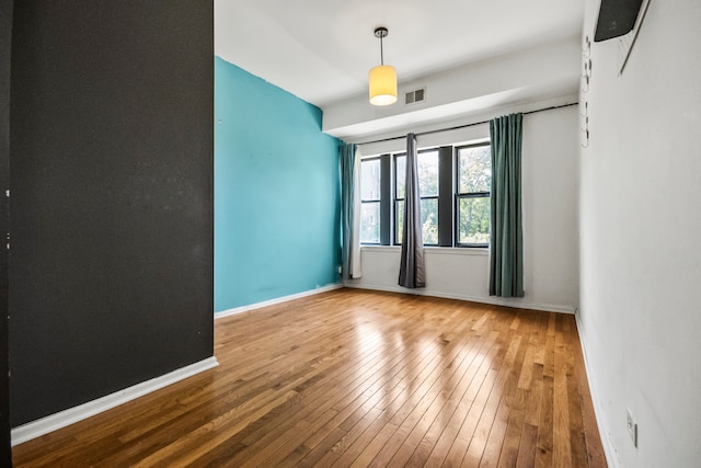 spare room featuring wood-type flooring