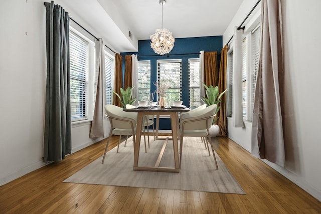 dining space featuring wood-type flooring and a chandelier