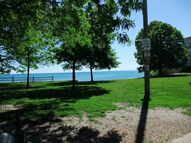 surrounding community featuring a water view and a lawn