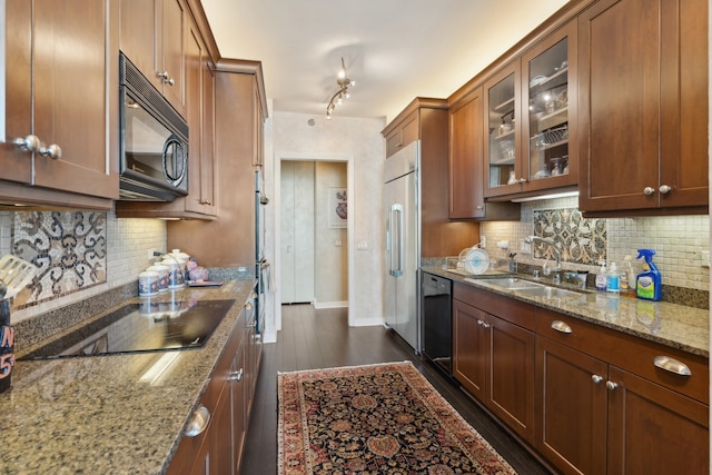 kitchen with dark hardwood / wood-style flooring, sink, light stone countertops, backsplash, and black appliances