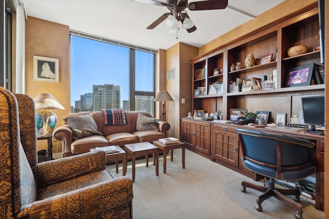 carpeted home office featuring built in desk and ceiling fan